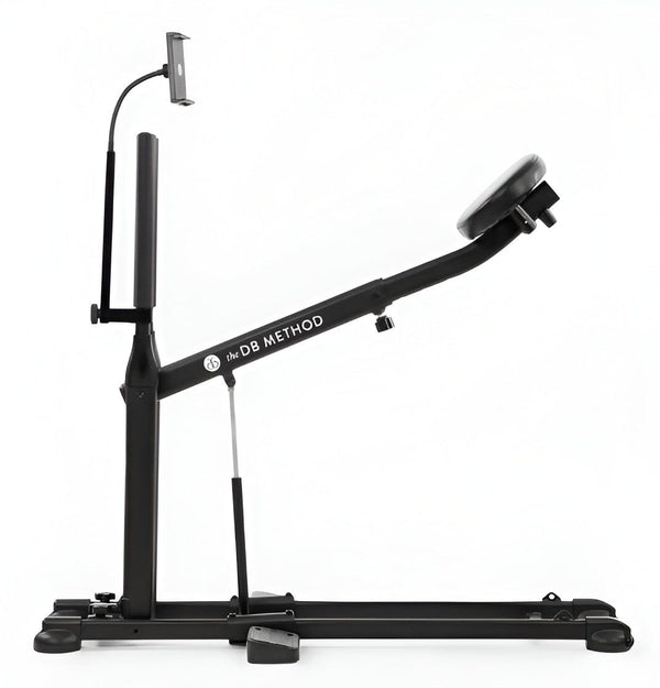 The DB Method squat machine with attached phone and tablet holder for guided home workouts.