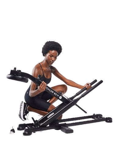 A woman demonstrates the working of the DB Method squat machine.